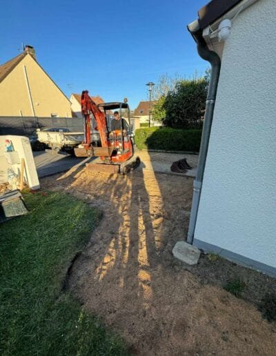 pelleteuse faisant un terrassement de jardin de maison