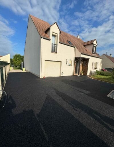 vue d'ensemble du sol enrobé noir neuf autour d'une maison