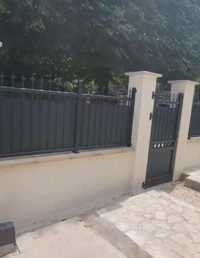 Détail construction mur de clôture sur muret avec couvertine et portillon noir