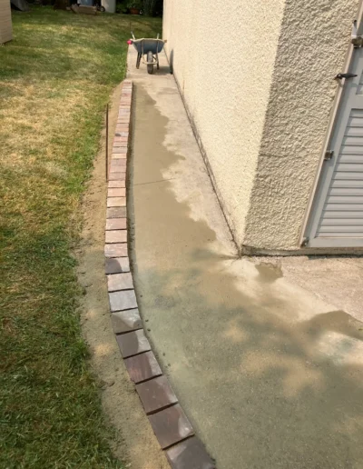 Création allée en pavé le long d'une maison dans les Yvelines avec bordures scellées