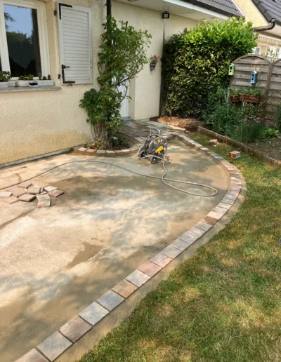 Fondation terrasse pavée pose de bordures courbes scellées au béton pour lit de sable