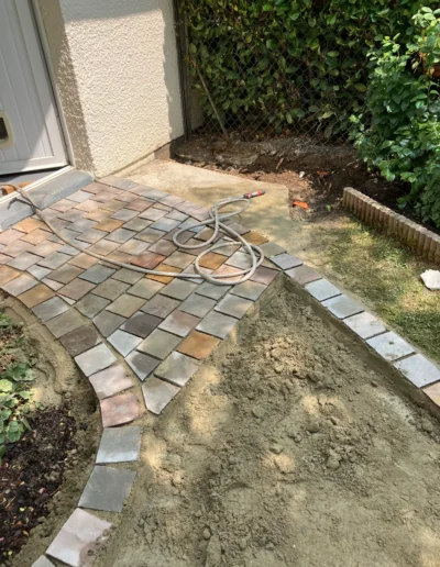 Technique pose pavés sur lit de sable stabilisé avec réglage précis des niveaux et joints